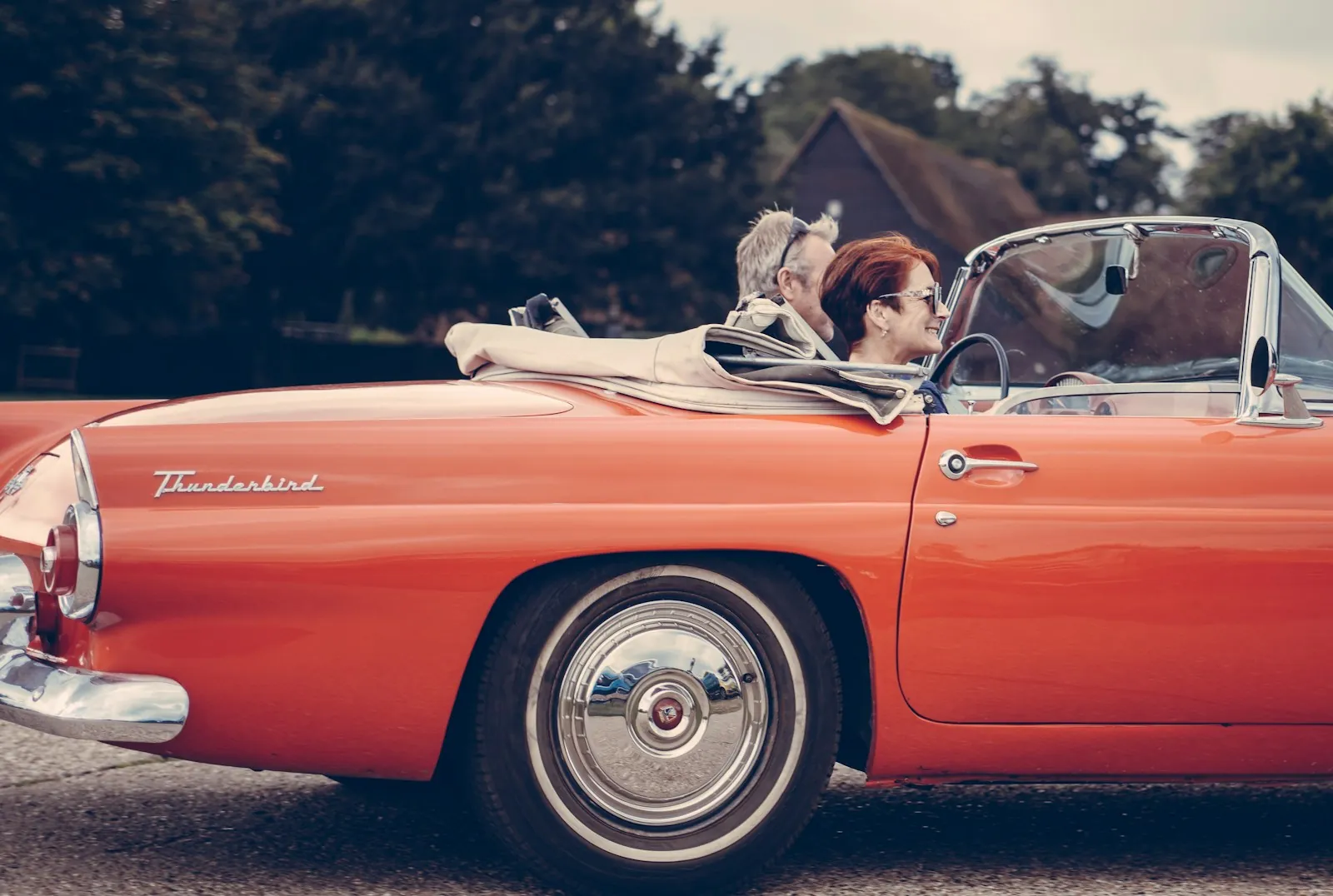 Two people cruising in a vintage convertible